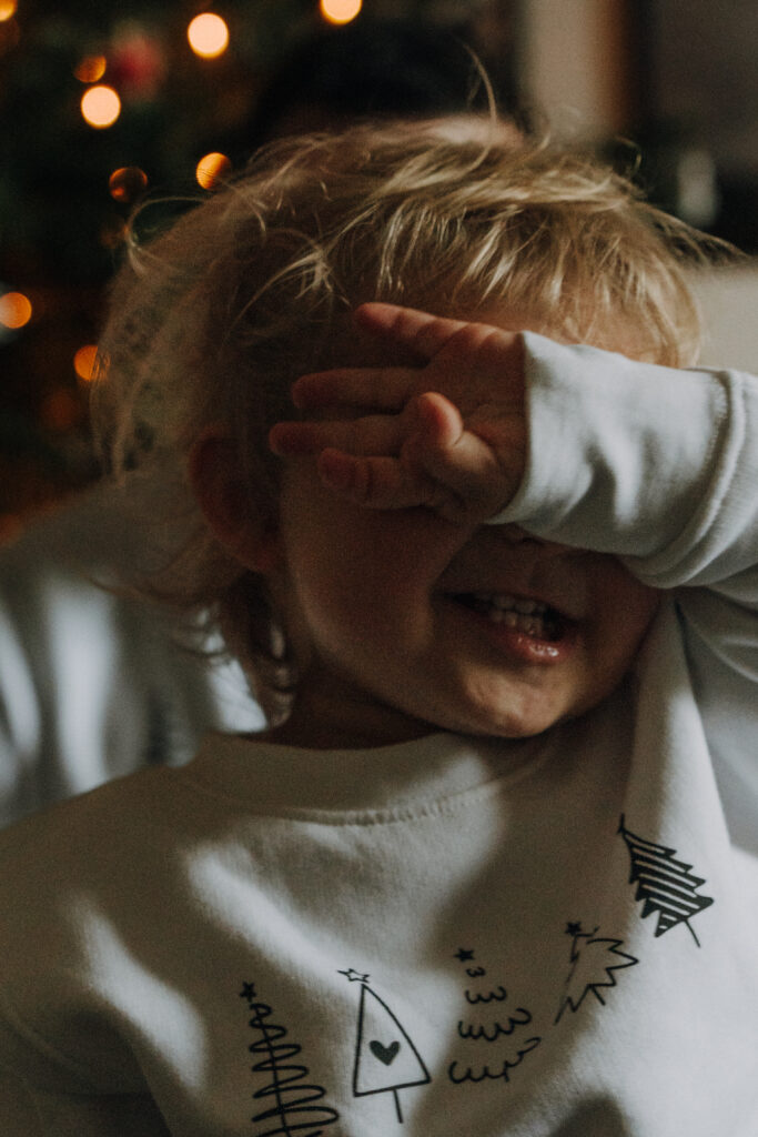 Kind spielt in weihnachtlicher Atmosphäre beim Familienshooting